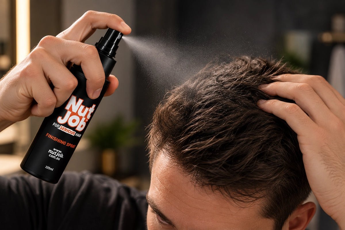 Man spraying Nut Job Finishing Spray onto his hair while lifting it with his other hand