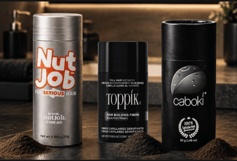 Nut Job, Toppik and Caboki hair fibre bottles on a bathroom vanity, each with a small pile of fibres in front